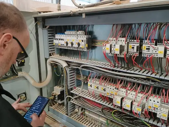 Engineer diagnosing an industrial electrical cabinet